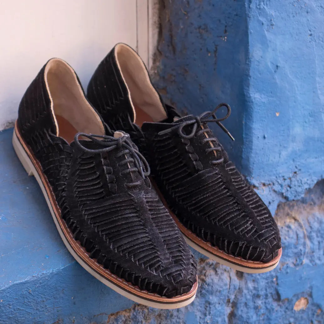 Les Derbies Autentico Suede Noir sont posées dans l'encadrement d'un fenêtre aux murs bleus.