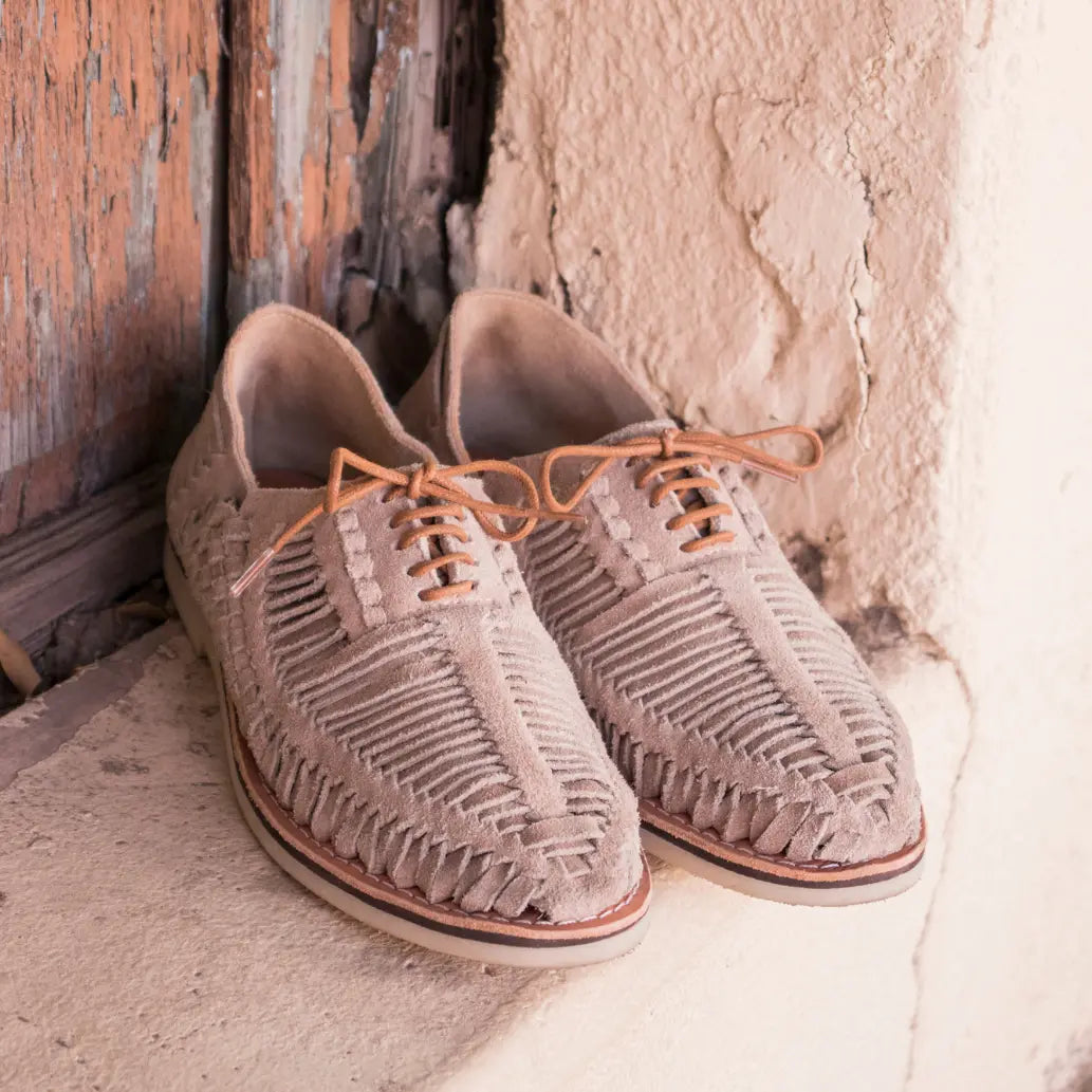 Les Derbies Autentico Suede Taupe sont posées dans l'embrasure d'une fenêtre beige.