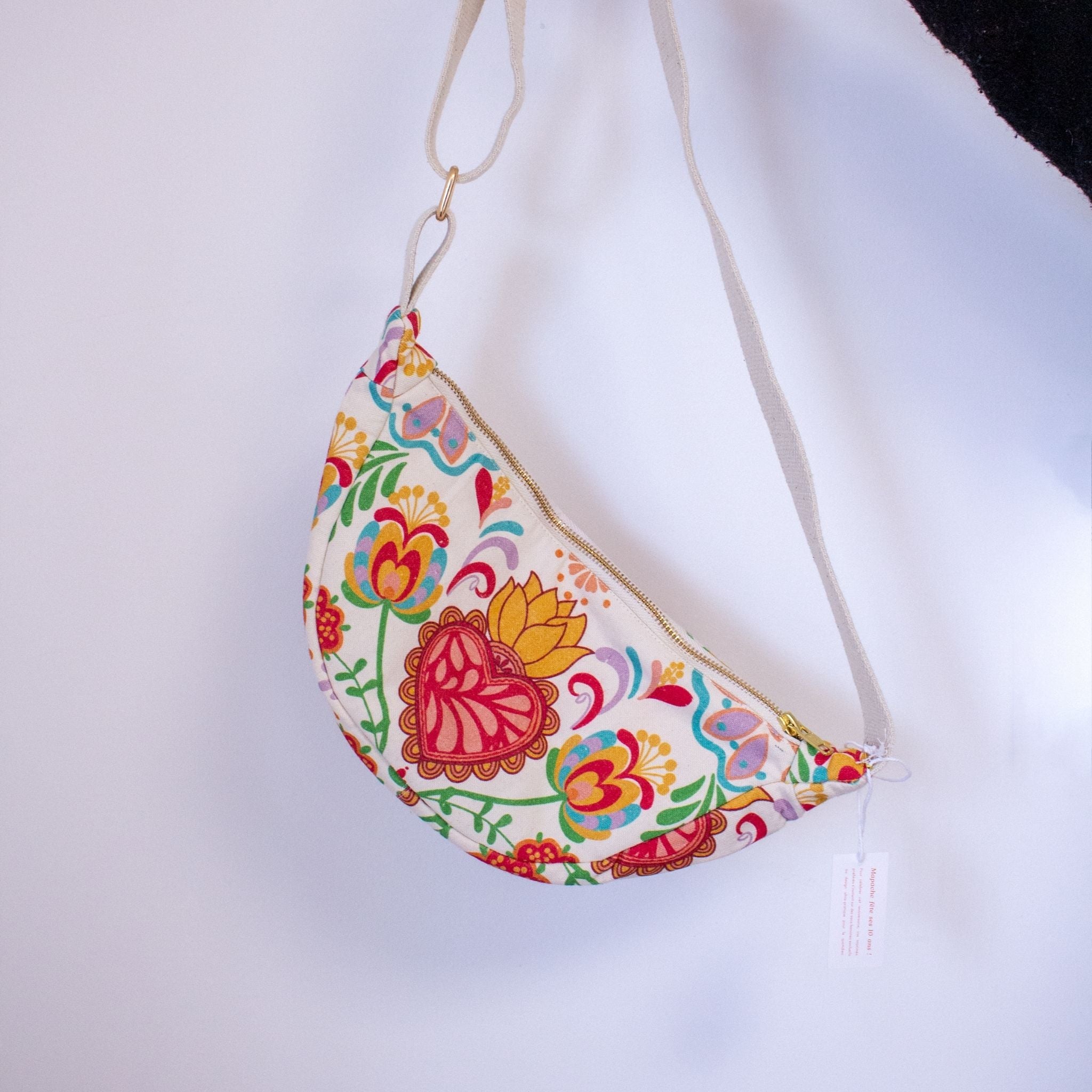 Banane Las Preciosas - Vue suspendue du dos avec grand cœur stylisé entouré de fleurs.