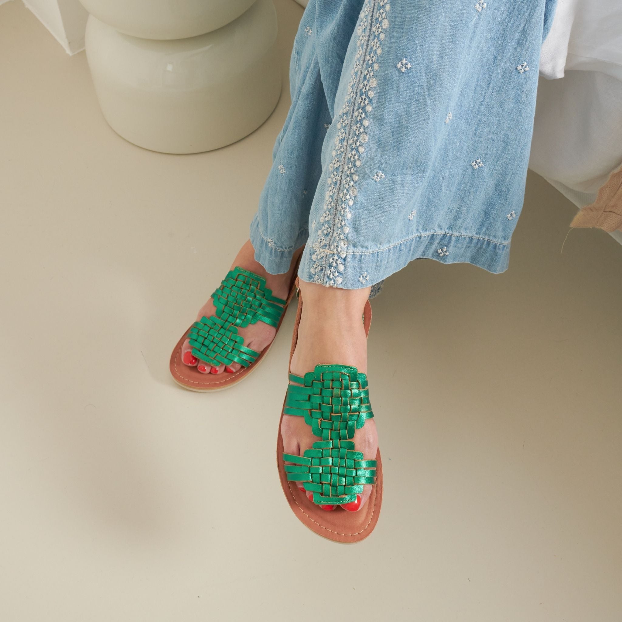 Bianca Vert Emeraude - Mapache - Claire porte des sandales en cuir vert émeraude, avec un design élégant et audacieux.