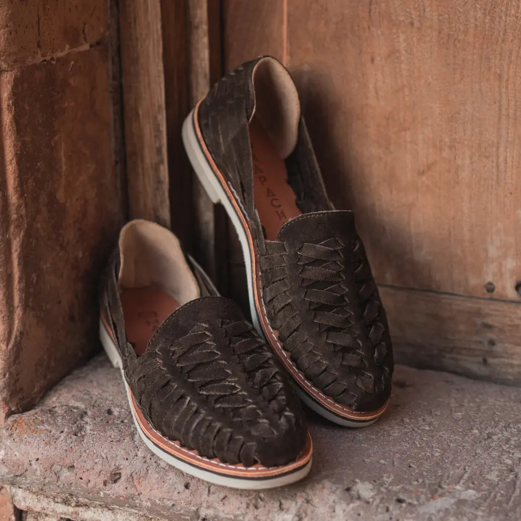 Les Mocassins Buena Vista Suede Brun sont posés dans l'embrasure d'une porte en bois.