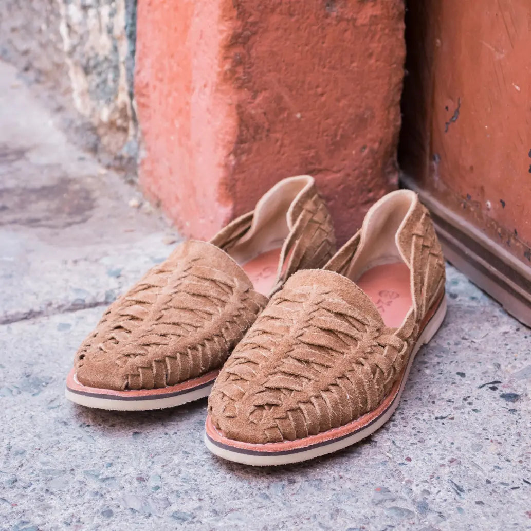 Les Mocassins Buena Vista Suede Moka sont posés sur du goudron devant une porte Terracotta.
