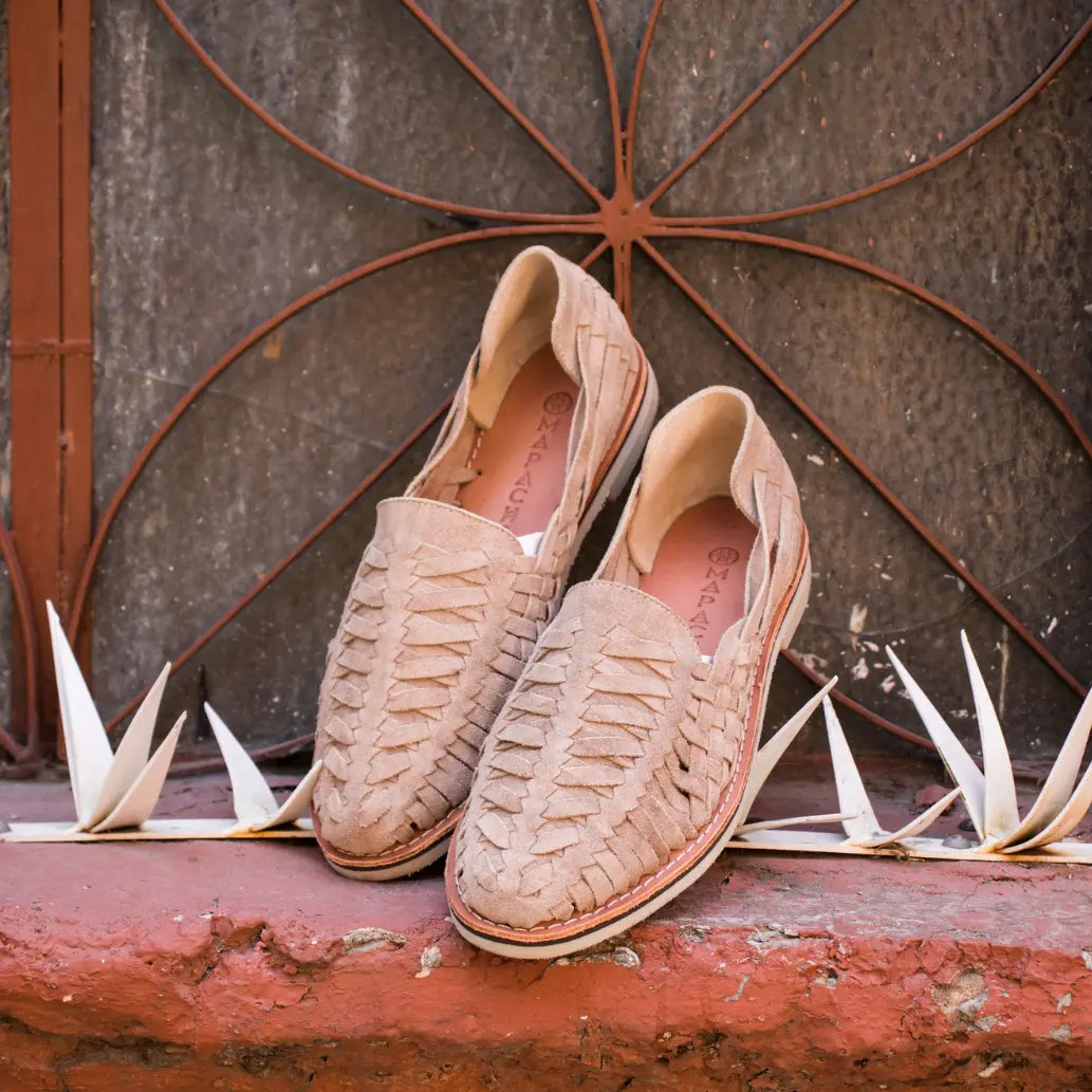 Les Mocassins Buena Vista Taupe sont appuyé contre une vitre décorée de métal terracotta.