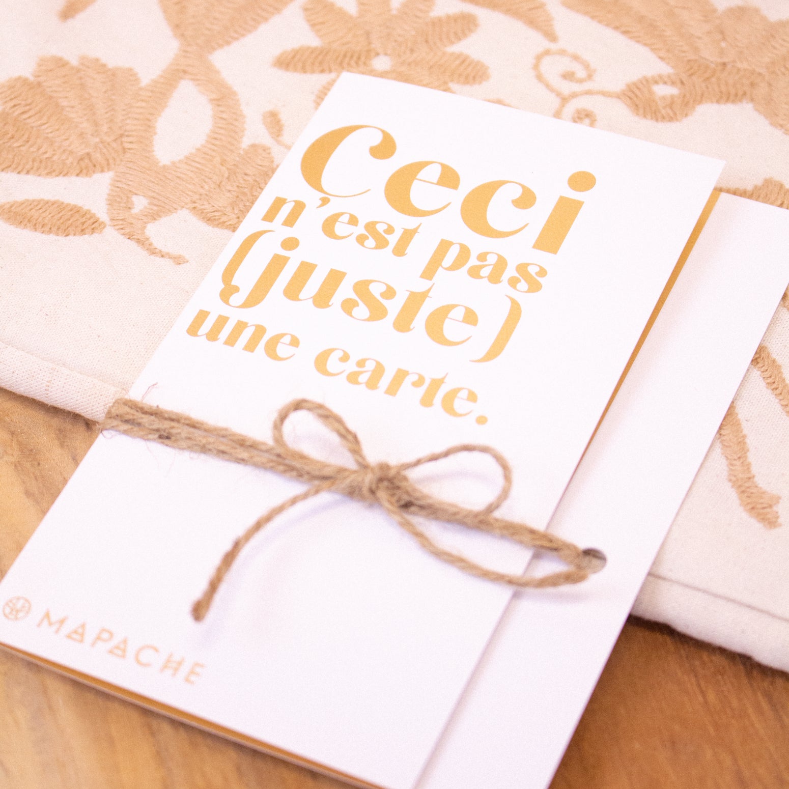 Une carte avec écrit "Ceci n'est pas une carte" repose sur une table.