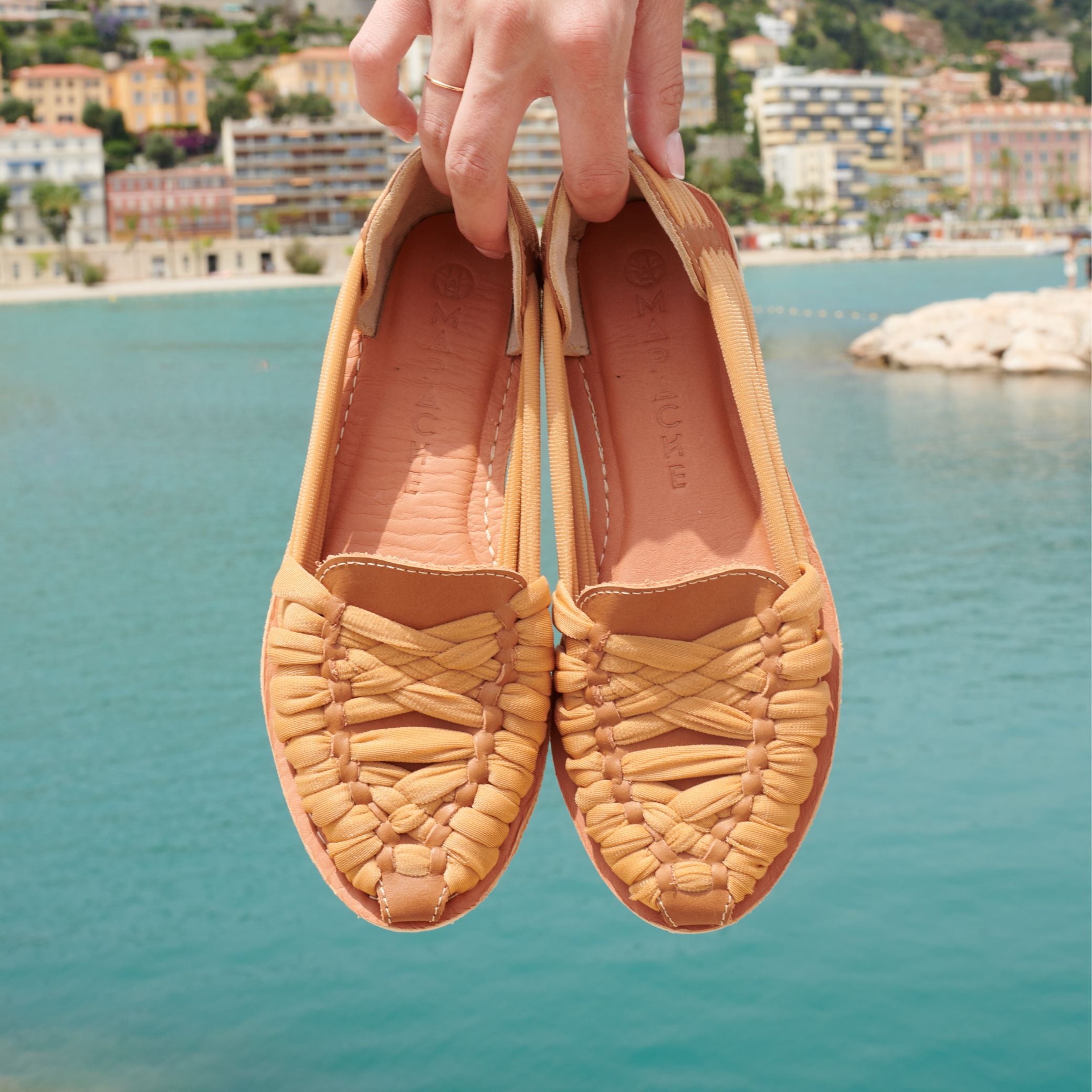 Mocassins Rita Nude en cuir camel avec tressage en nylon camel, tenus à la main par Claire.