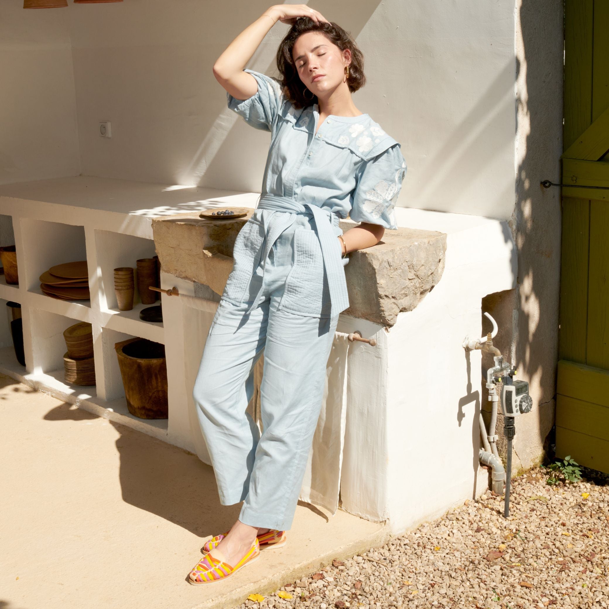 Claire prend le soleil et porte les Rita Summer en cuir crème et tressage en nylon coloré.