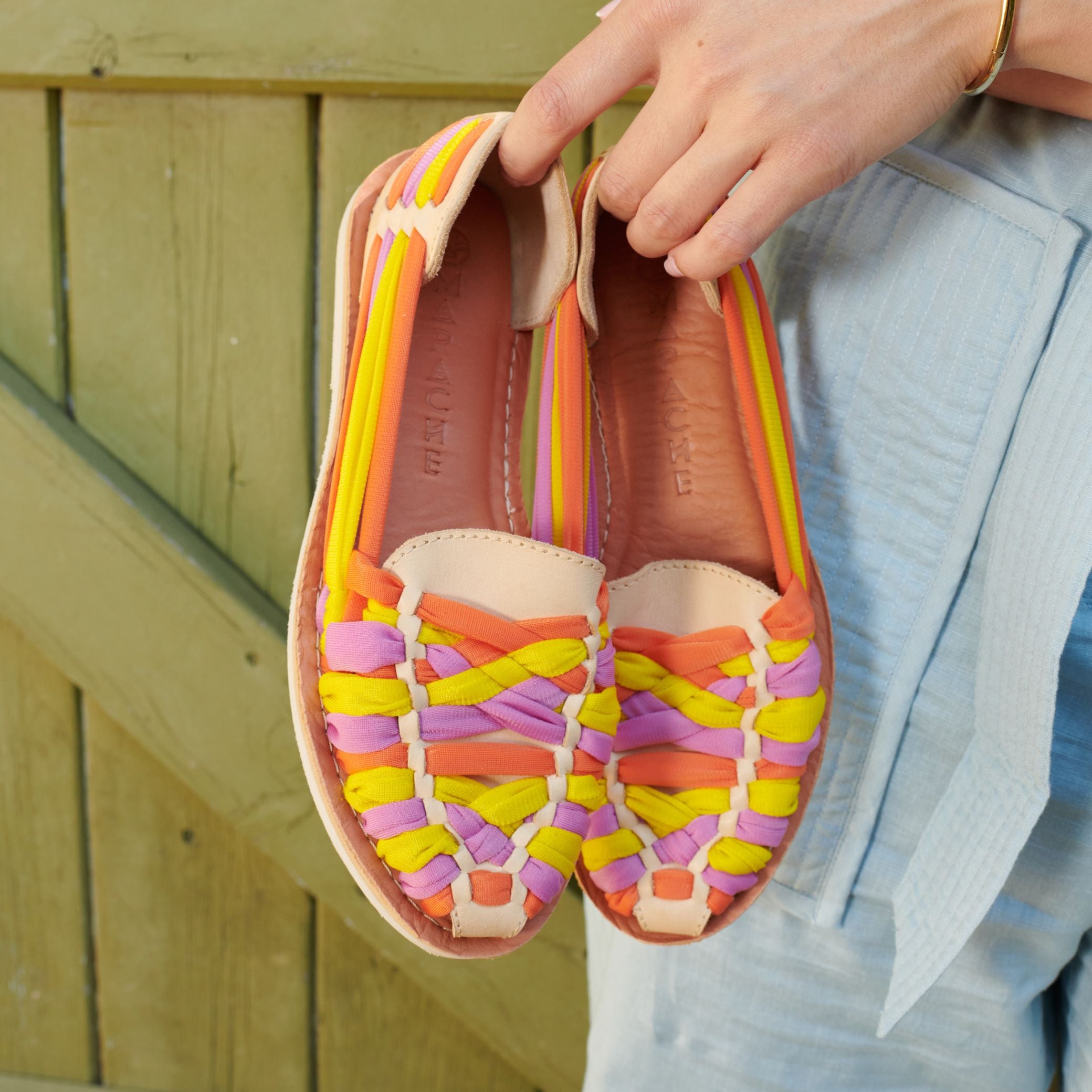 Mocassins Rita Summer en cuir crème avec tressage jaune, orange et rose, tenus à la main par Claire.