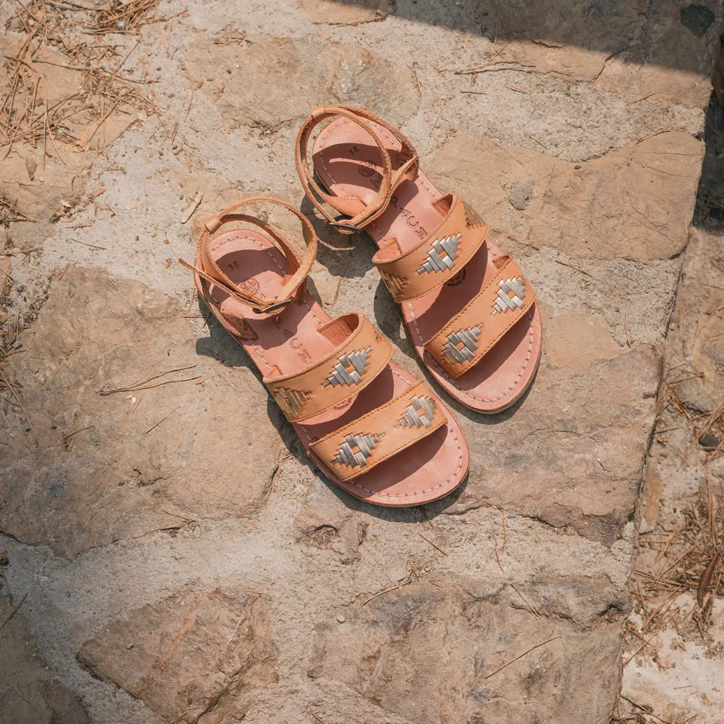 Les Sandales Rosa Naturel champagne sont posées sur une marche en pierre sous le soleil.