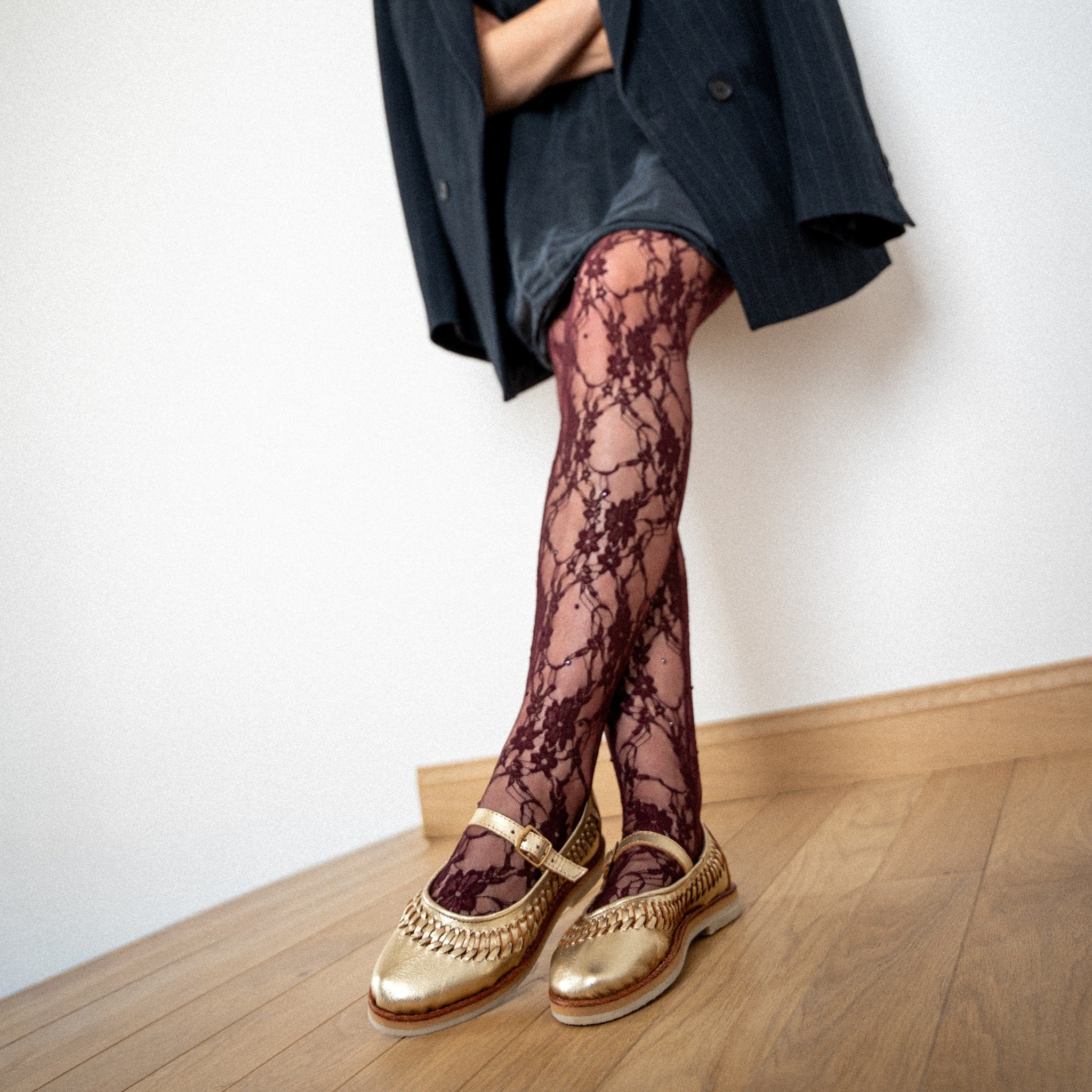 Ballerine Sofia Champagne portée avec un collant bordeaux en dentelle