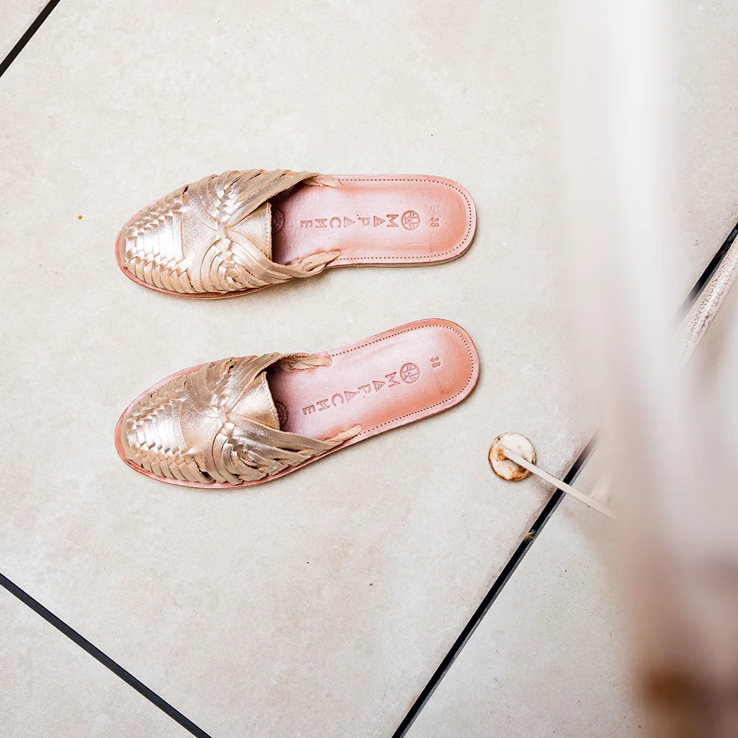 Les Mules Sonora Champagne sont posées sous le soleil sur un carrelage écru.