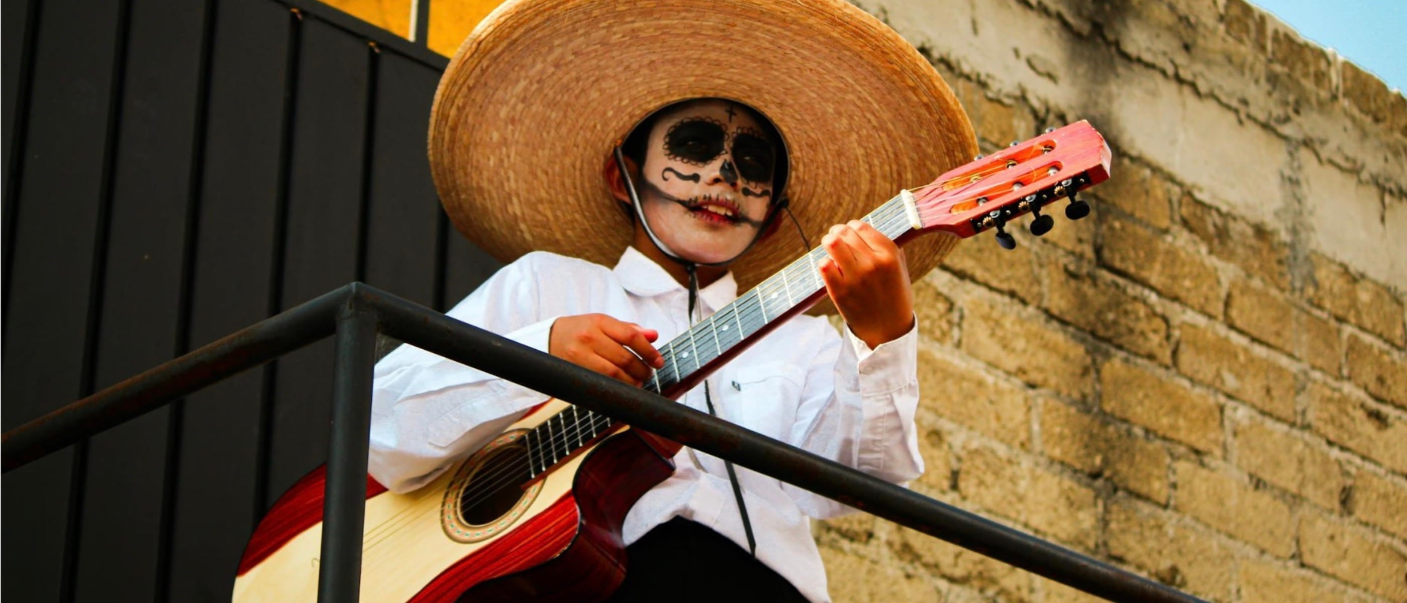 Enfant jouant de la guitare avec maquillage traditionnel Mexique - destination kids friendly - blog Mapache